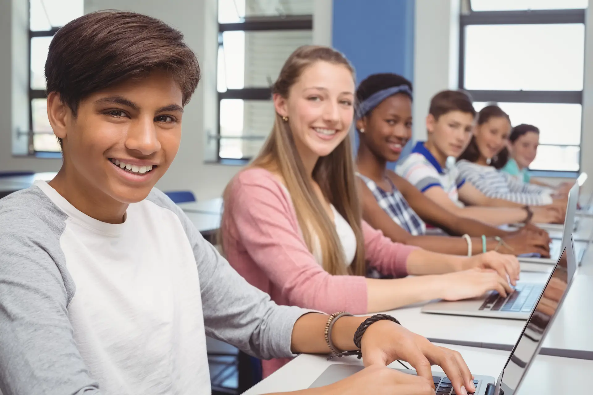 portrait-of-students-using-laptop-in-classroom-minified